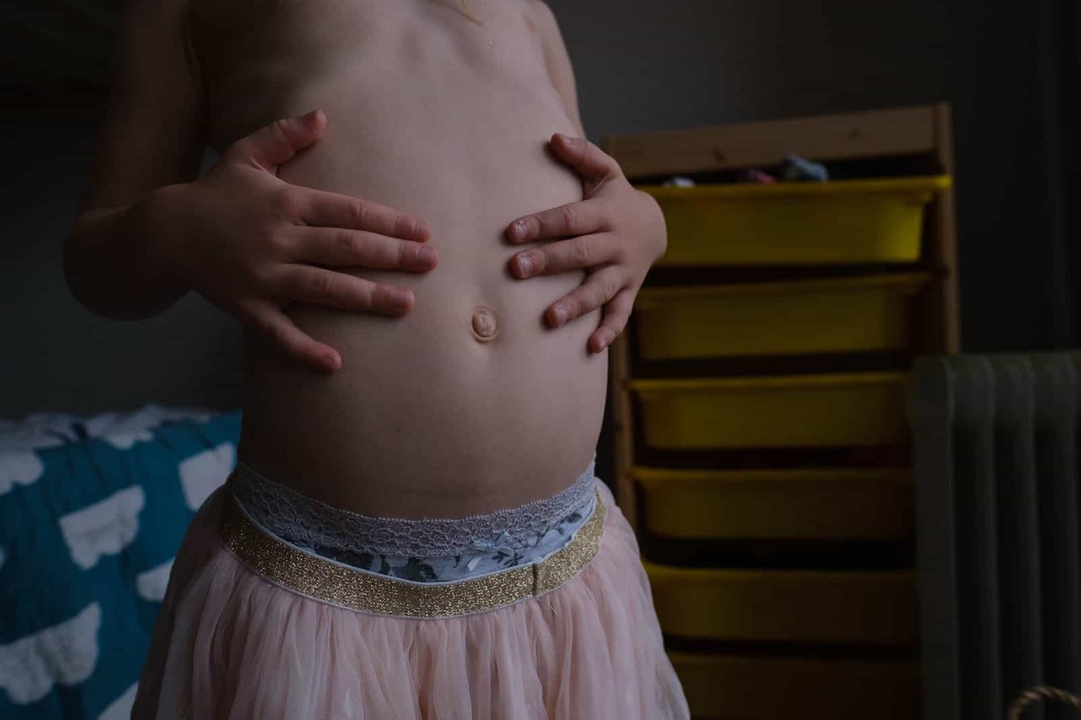 Close up colour image of a young girl showing her innie-outie belly button